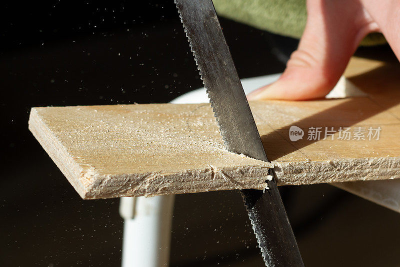 用竖锯锯木胶合板，锯屑从锯子飞到两边