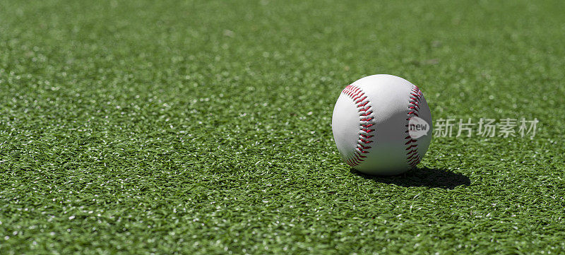 棒球在绿色的草地上。体育主题背景。水平运动主题海报，贺卡，标题，网站和应用程序