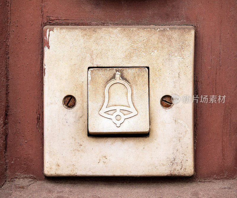 简单的老门铃，矩形门铃开关上有一个铃铛的符号，对象宏，极端特写，正面视图，正面拍摄，没有人，没有人。大楼入口磨损的门铃按钮近距离