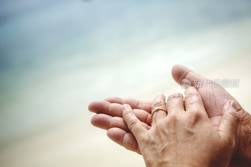 夏天的海边，手上拿着订婚戒指