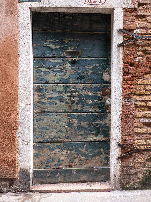 威尼斯老建筑上风化的木制前门