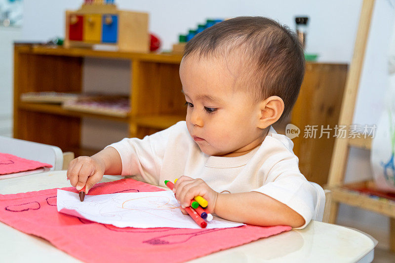 幼儿用油笔在纸上写字