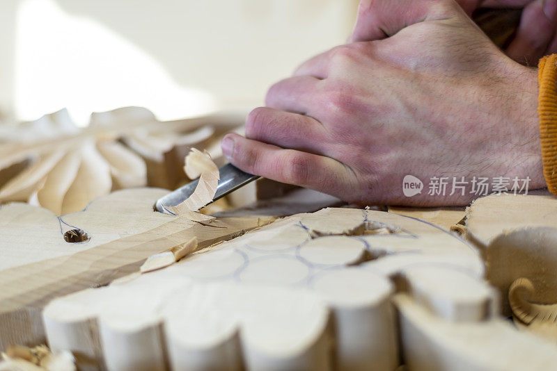 用凿子在木头上工作并进行木雕的木雕匠。