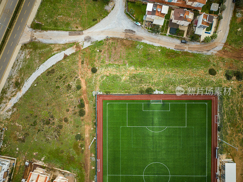 绿草如茵的足球场和住宅区。鸟瞰图