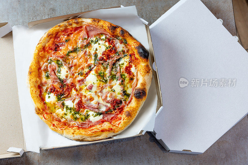 圆烤火腿和奶酪披萨在开放的披萨盒