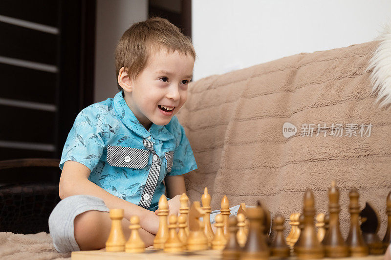 可爱的白人小男孩在家里下棋。小男孩与朋友、姐妹、兄弟一起玩棋盘游戏，积极发展国际象棋策略。早期发展和额外教育。