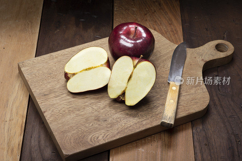 红苹果放在砧板上，放在木桌上