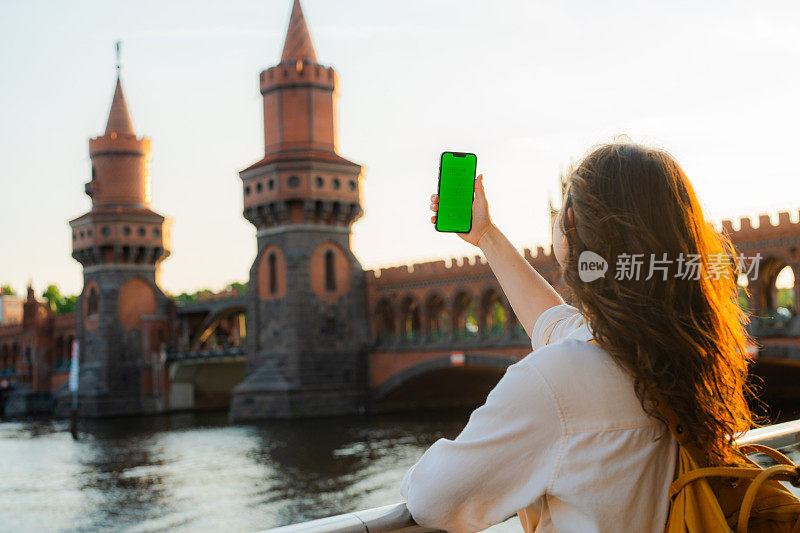 在柏林，一名女子边走边用智能手机拍照
