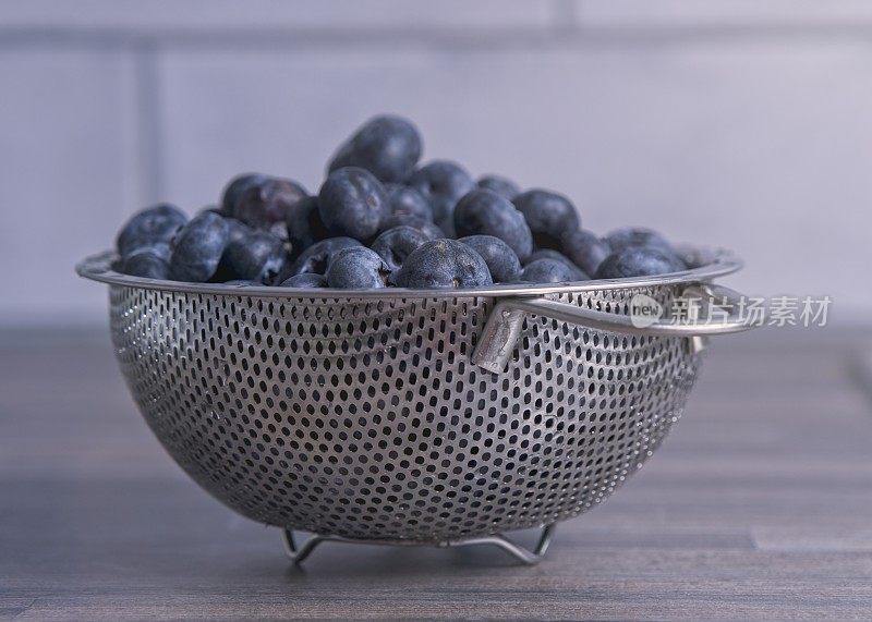不锈钢滤锅里刚洗过的蓝莓特写