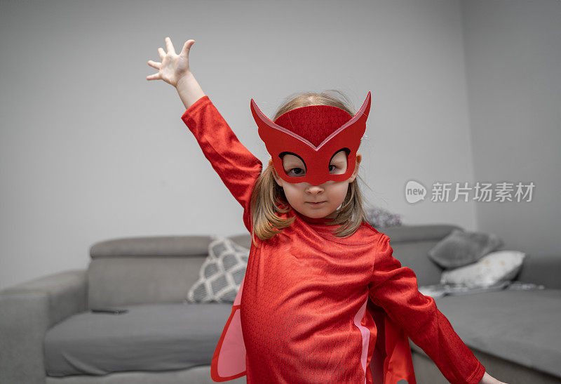 可爱的小可爱穿着红色的超级英雄装，只是在玩得开心，拯救世界。