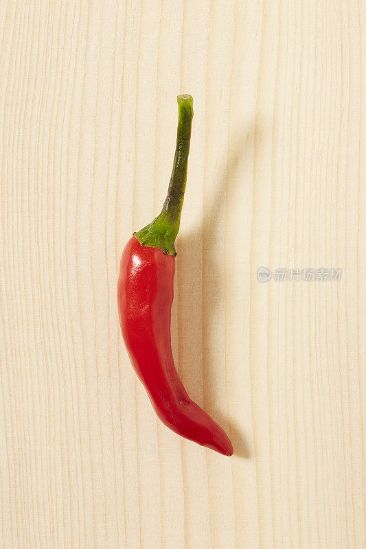 木质背景上的新鲜辣椒。红色的颜色。