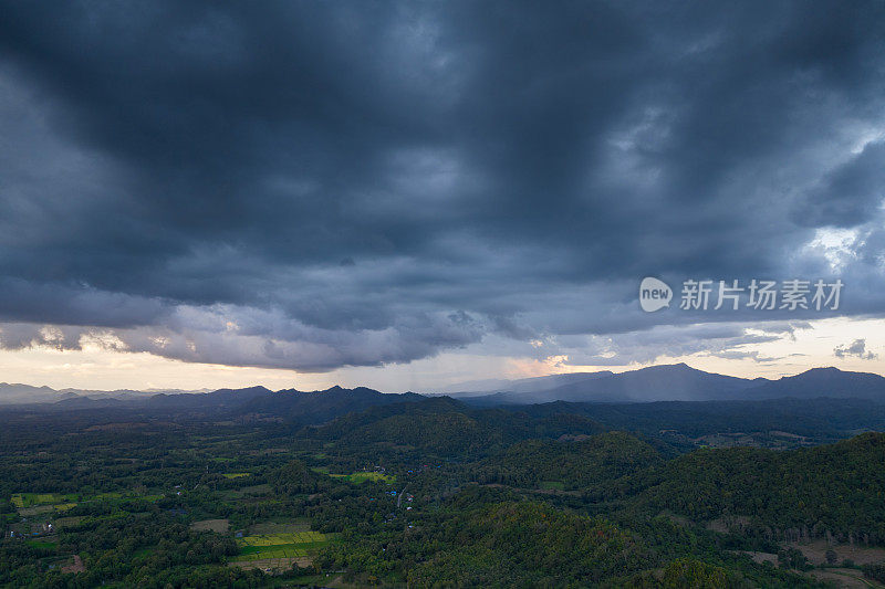 巨大的黑色雨云和暴雨落在山区的森林地区。