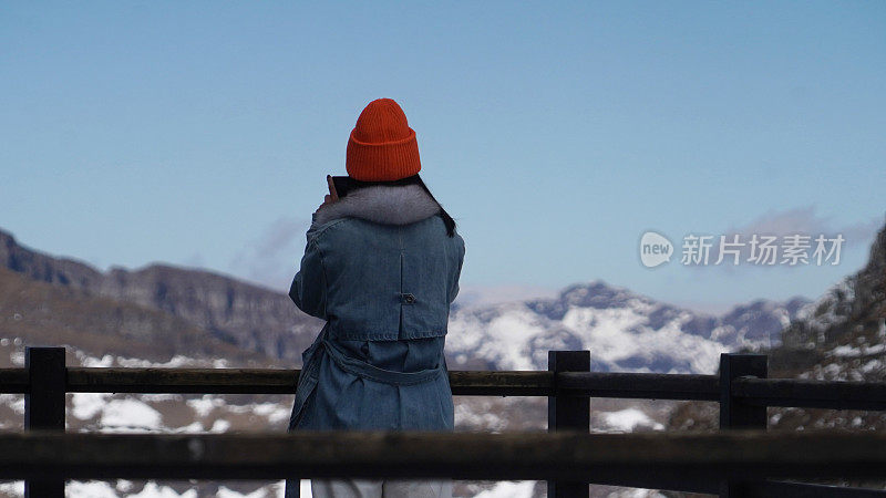 一个女人在寒冷的天气里穿行于白雪覆盖的山林之中