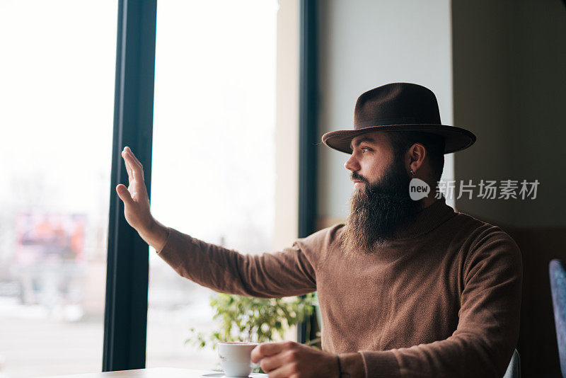 面带微笑的胡子英俊的年轻人挥手