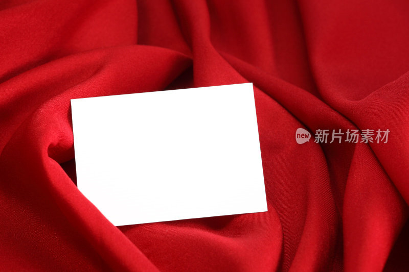 红色缎子上有空白的白色卡片