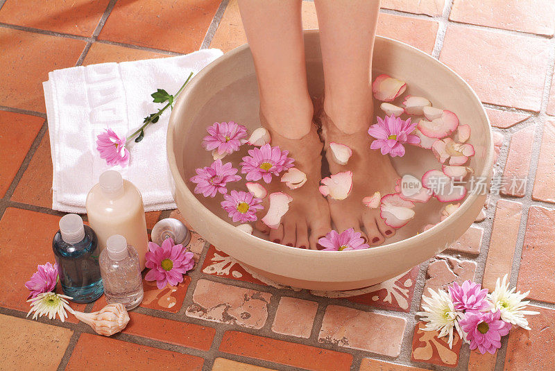 脚站在一盆放着花的水里，旁边放着洗液