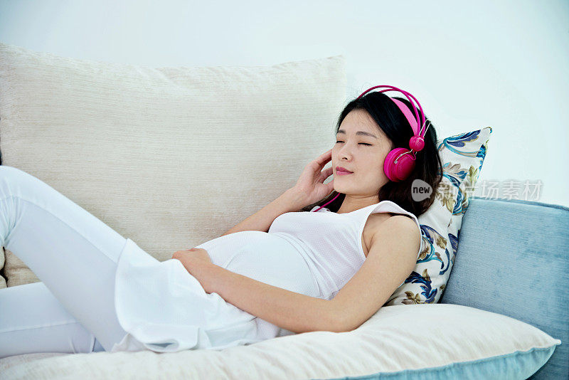 孕妇坐在沙发上听音乐