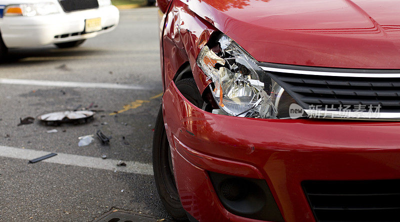 一辆前灯被撞坏的红色汽车