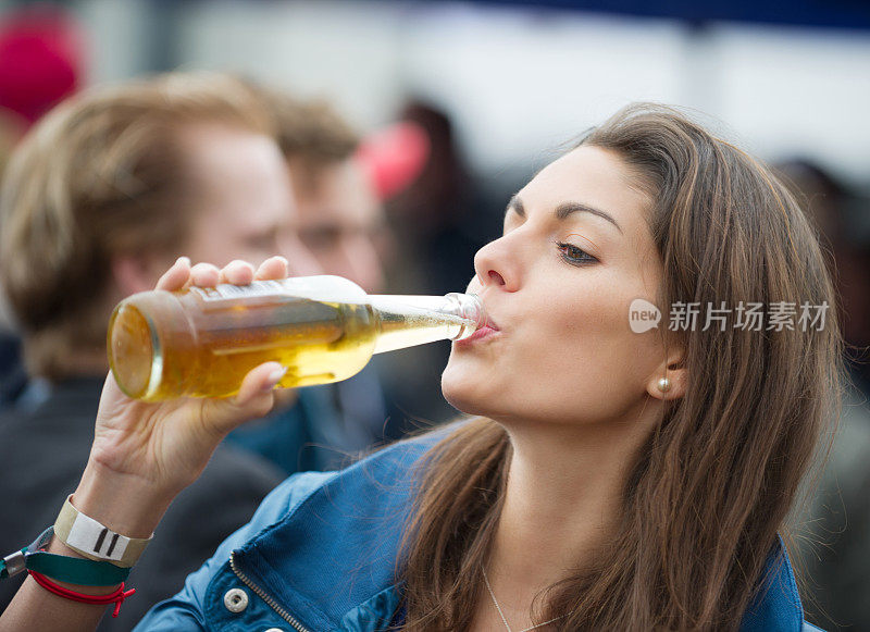 在音乐节上喝啤酒的女人