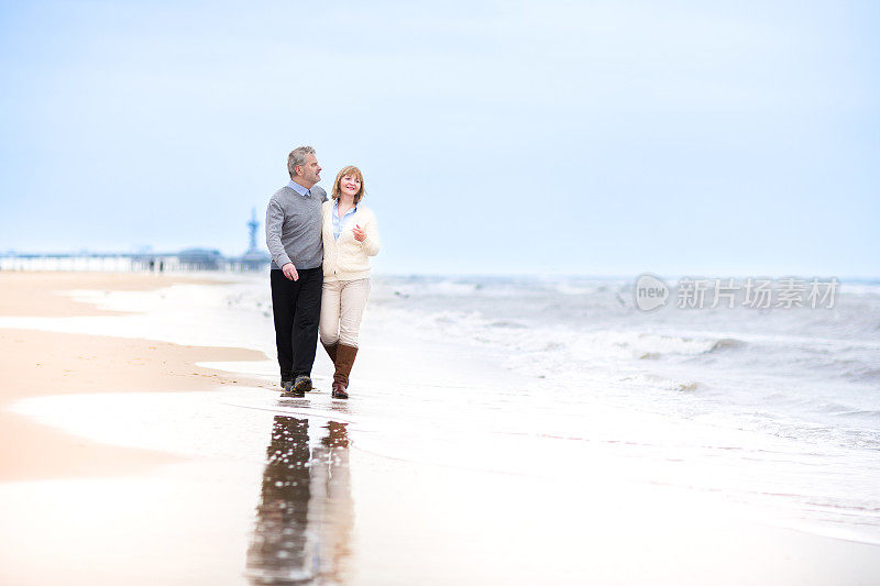 一对幸福的中年夫妇在荷兰的海滩上散步