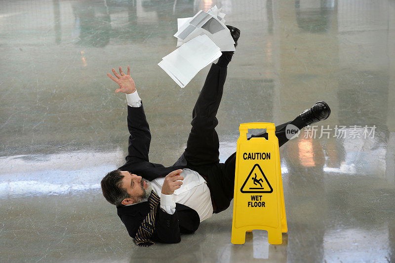 商人摔倒在潮湿的地板上