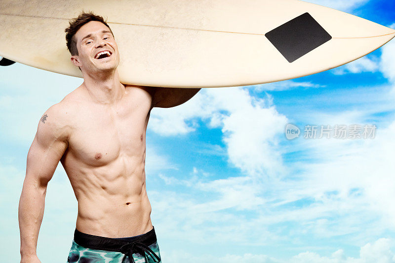 肌肉发达的男人扛着冲浪板