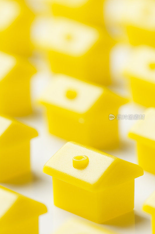 白色背景上一模一样的黄色塑料房子