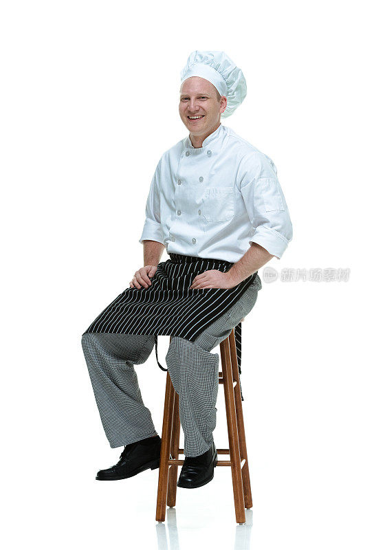 愉快的厨师坐在凳子上，看向别处