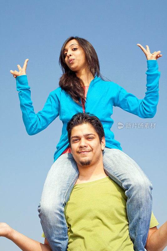 年轻开朗的印度男性成年人肩上背着女性朋友