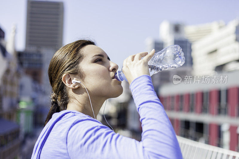 女性在跑步后喝水的特写