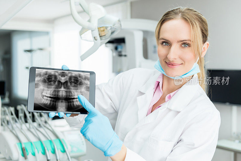 迷人的牙医在数码平板上展示x光片