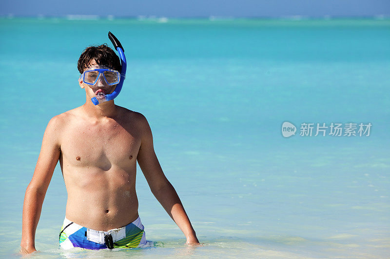 十几岁的男孩在热带水域戴着通气管和潜水面罩