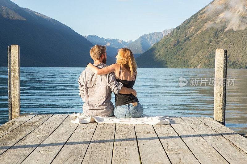 年轻夫妇在湖边码头上拥抱