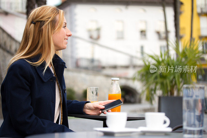 一个女人在咖啡馆用手机享受咖啡休息时间