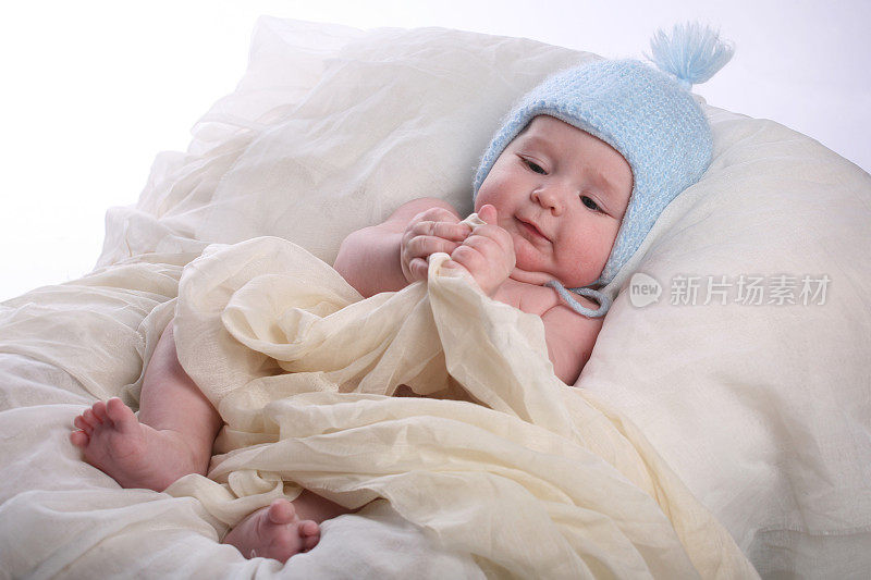 可爱和严肃的婴儿躺在蓝色漂亮的帽子