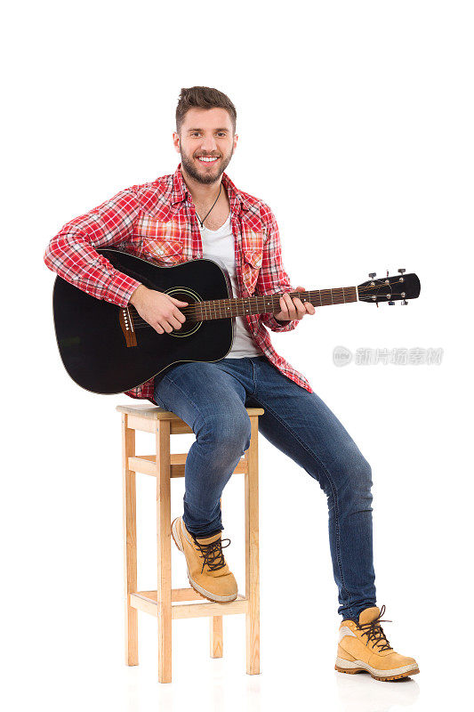 吉他手在椅子上摆姿势