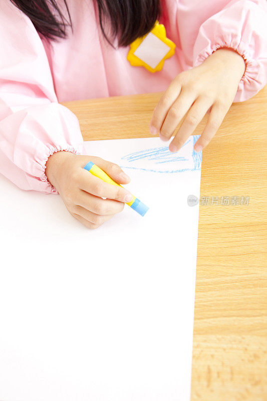 幼儿园的女孩们用手中的蜡笔画画