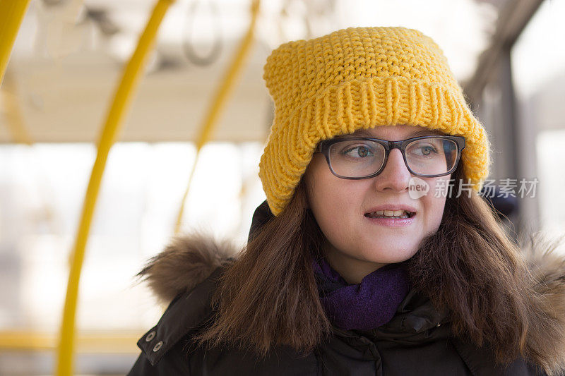 戴黄色帽子的年轻女子乘坐公共交通工具