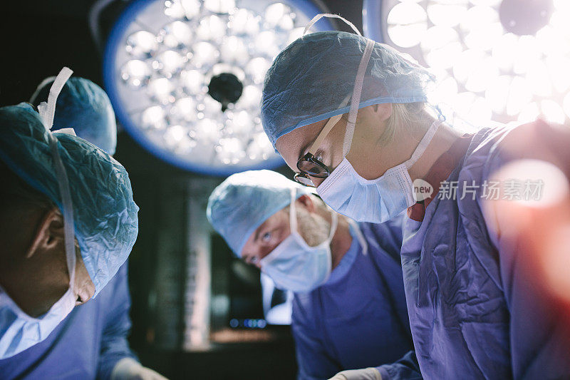专注的外科医生和她的团队一起做手术