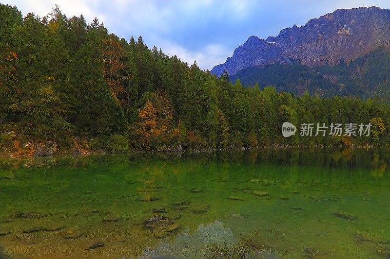 宁静和田园诗般的Eibsee高山绿松色湖泊反射在美丽的黎明-长时间的曝光，与Waxenstein和Zugspitze山峰-戏剧性和雄伟的景观在巴伐利亚阿尔卑斯山，金色的秋天-加米施，德国巴伐利亚