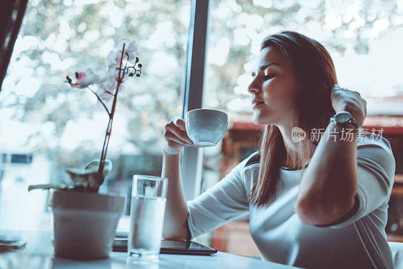 舒适的女性在家里，早上第一次喝咖啡