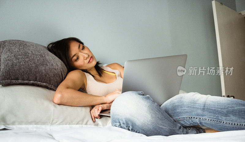 在床上用笔记本电脑的女人