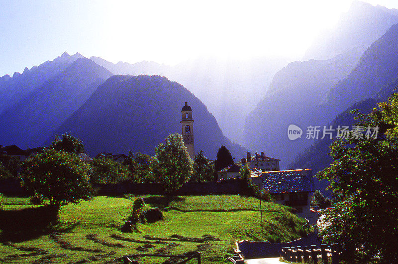清晨的阳光在瑞士的阿尔卑斯和村庄牧场的索里奥瑞士村