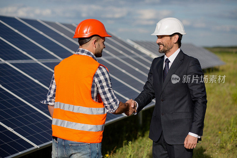 商人和工头在太阳能站握手。