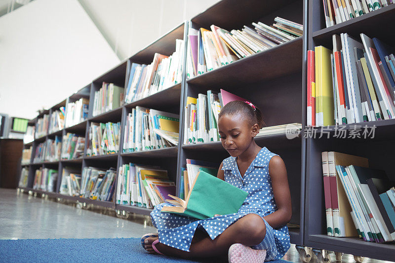 女孩在图书馆的书架旁看书