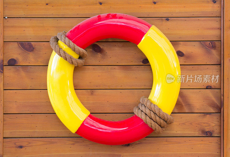 木墙上挂着黄色和红色的救生圈