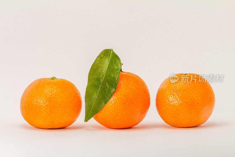 三个柑橘，一个绿叶子。