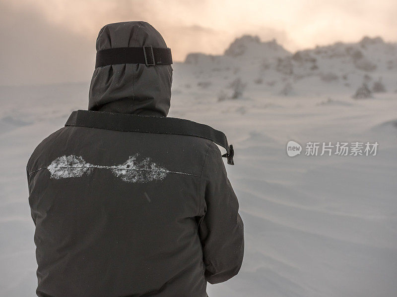 后视图的摄影师站在户外的雪山和拍照