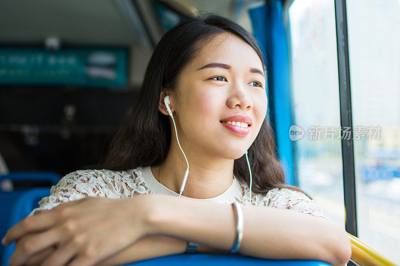 在公共汽车上听音乐的女孩