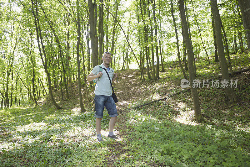 成年男子背着背包在森林里徒步旅行